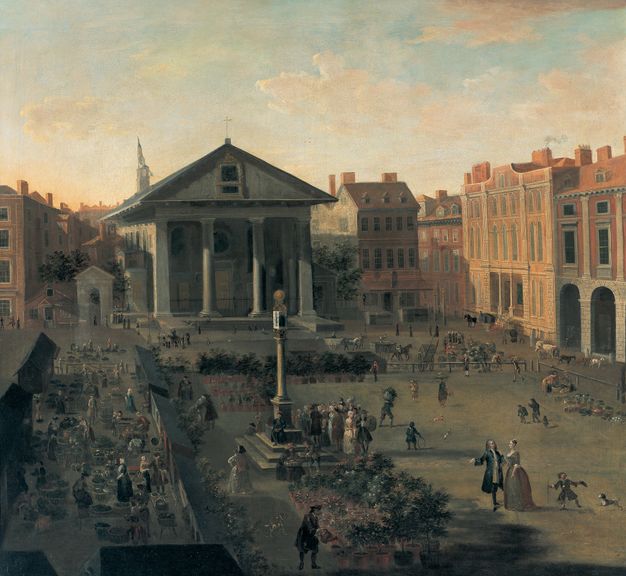 Oil painting depicting a bustling marketplace scene in a European city square. The composition is centered around a prominent classical building with columns, likely a church or civic structure. Surrounding the square are various stalls and vendors, with wares displayed in baskets, and groups of people engaging in trade and conversation. The architecture of the surrounding buildings is characterized by red brick facades and arched windows.